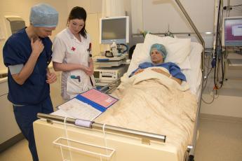 Verpleegkundige draagt zwangere over aan chirurg